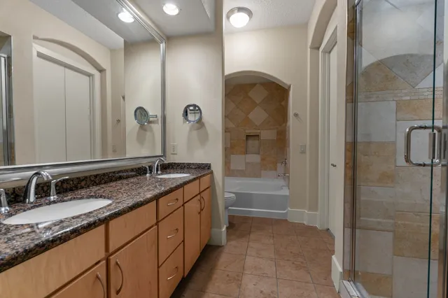 a bathroom with a granite countertop sink a mirror and a bathtub