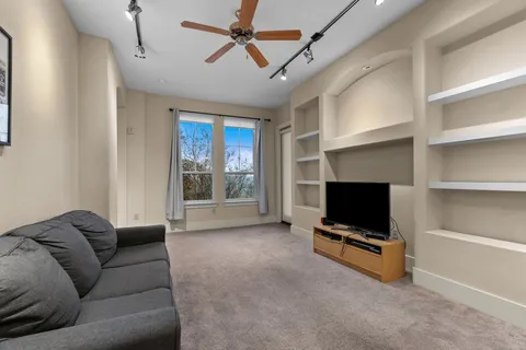 a living room with furniture a flat screen tv and a window