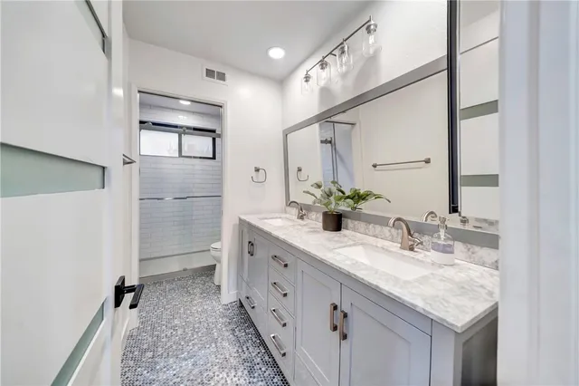 a bathroom with a granite countertop toilet and a shower