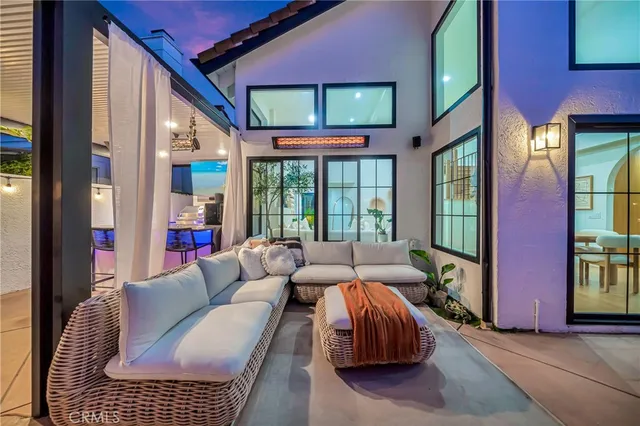 a view of a patio with table and chairs potted plants and floor to ceiling window