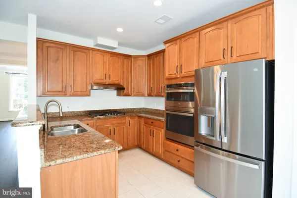 a large white kitchen with wooden floor