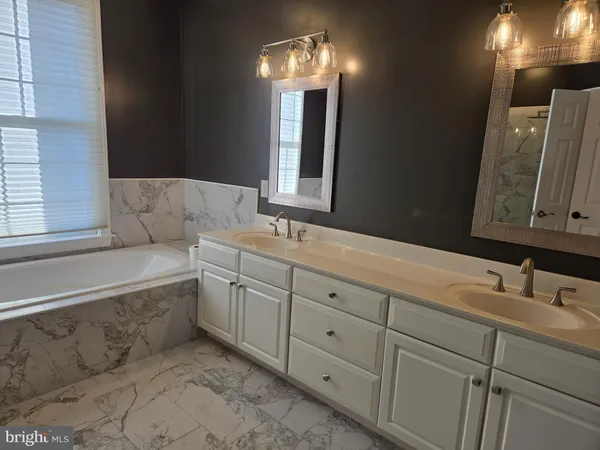 a view of a room with wooden floor chandelier and windows