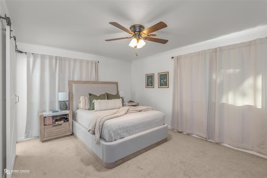 146 Bolinger Hill Road Plain Dealing, LA 71064 - Photo 19 of 32 a bedroom with a bed and a chandelier