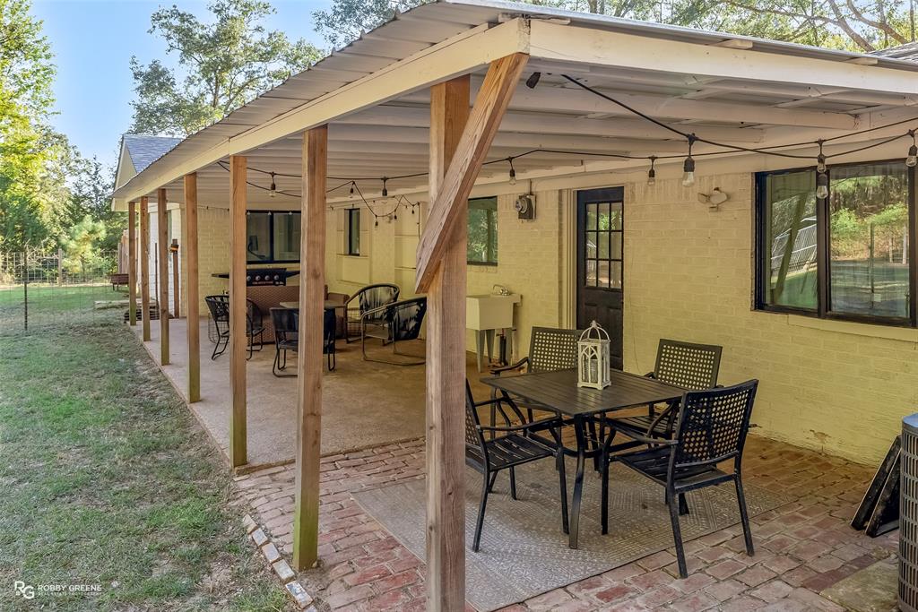 146 Bolinger Hill Road Plain Dealing, LA 71064 - Photo 28 of 32 a view of a patio with table and chairs and potted plants