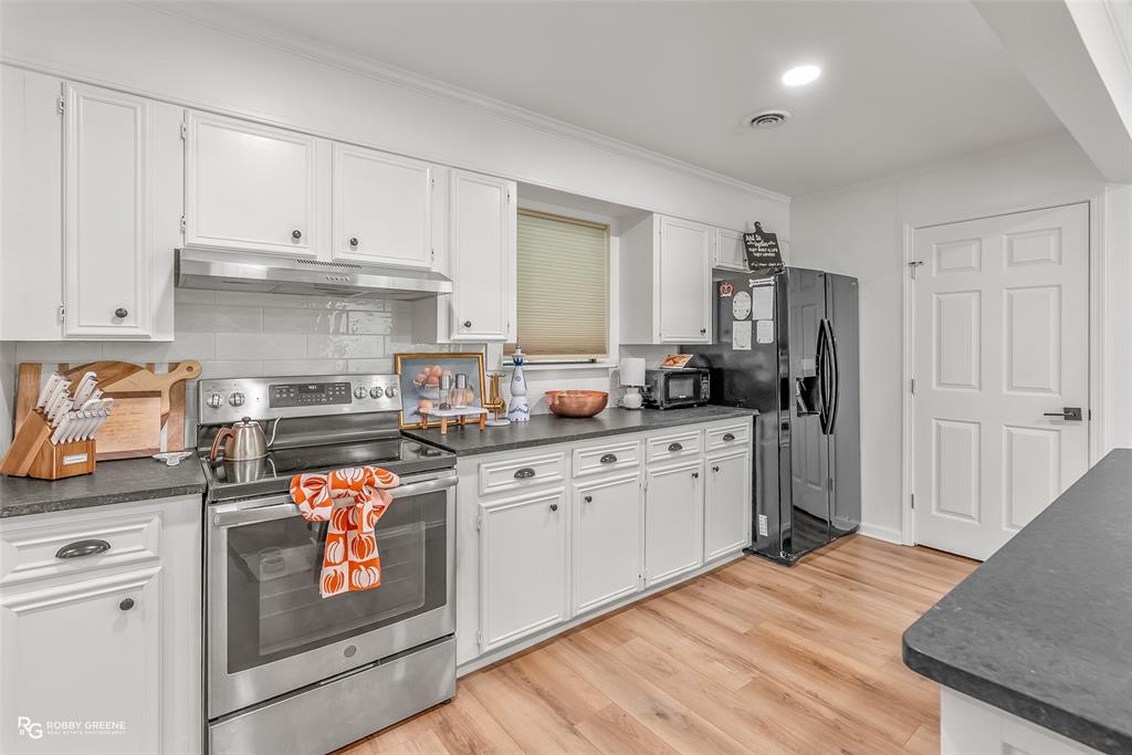 146 Bolinger Hill Road Plain Dealing, LA 71064 - Photo 9 of 32 a kitchen with granite countertop white cabinets and white appliances