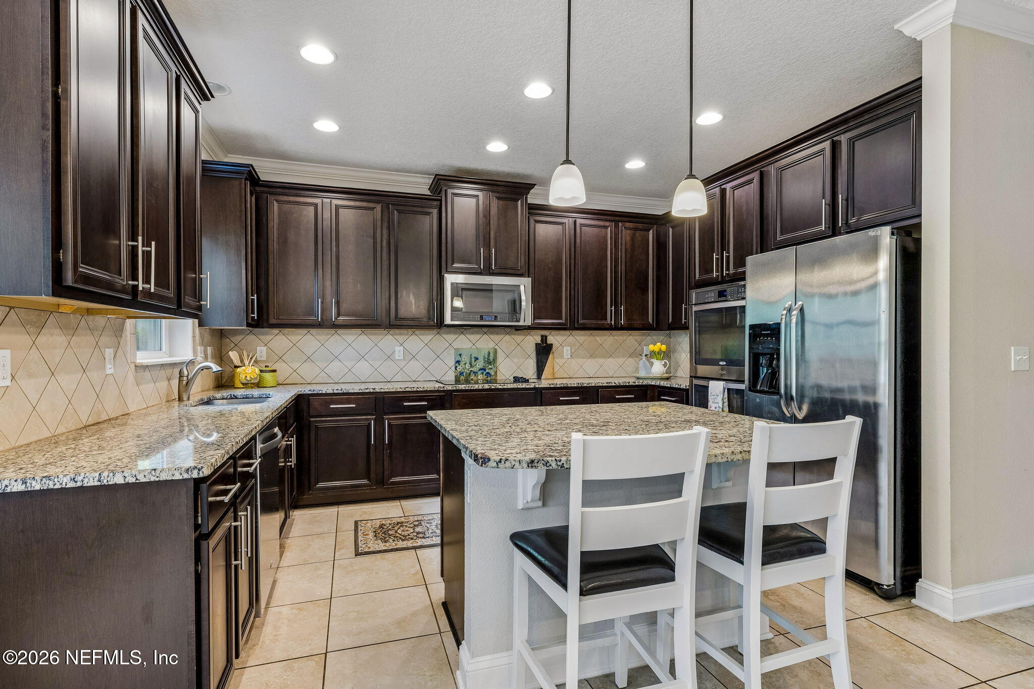 12198 Ridge Crossing Way Jacksonville, FL 32226 - Photo 18 of 67 a kitchen with stainless steel appliances granite countertop a refrigerator a sink a stove a microwave and island