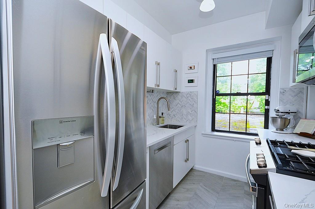 192 Garth Road, Unit TP Scarsdale, NY 10583 - Photo 14 of 43 The thoughtfully renovated kitchen is a chef’s delight, showcasing stainless steel appliances, custom white cabinetry, abundant quartz countertops, and generous workspace.