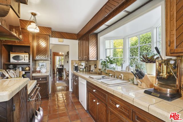 a bedroom with a bed a chandelier and a dresser