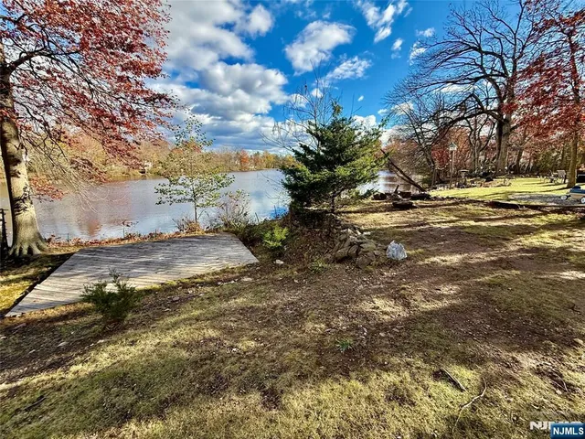 a front view of a house with swimming pool next to a yard