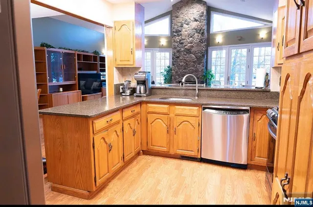 a view of a kitchen with stainless steel appliances granite countertop a refrigerator and a sink
