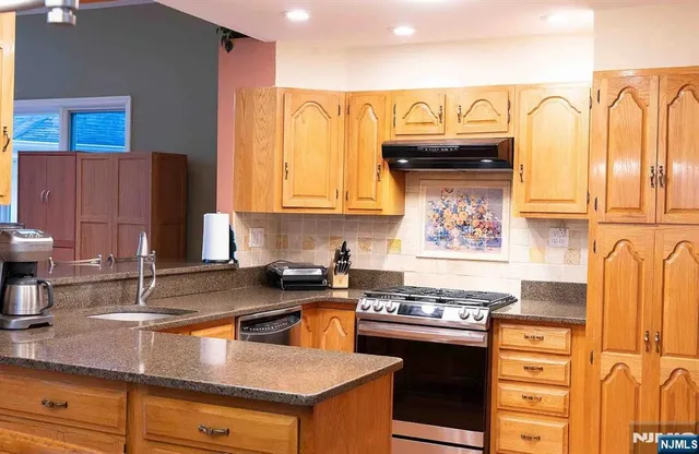 a kitchen with stainless steel appliances granite countertop a stove and a sink