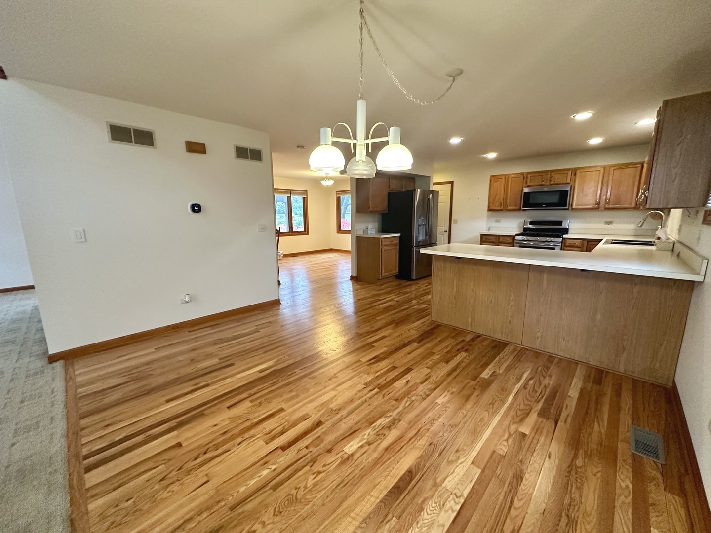 4216 White Ash Road Crystal Lake, IL 60014 - Photo 10 of 34 a view of a living room and kitchen with stainless steel appliances