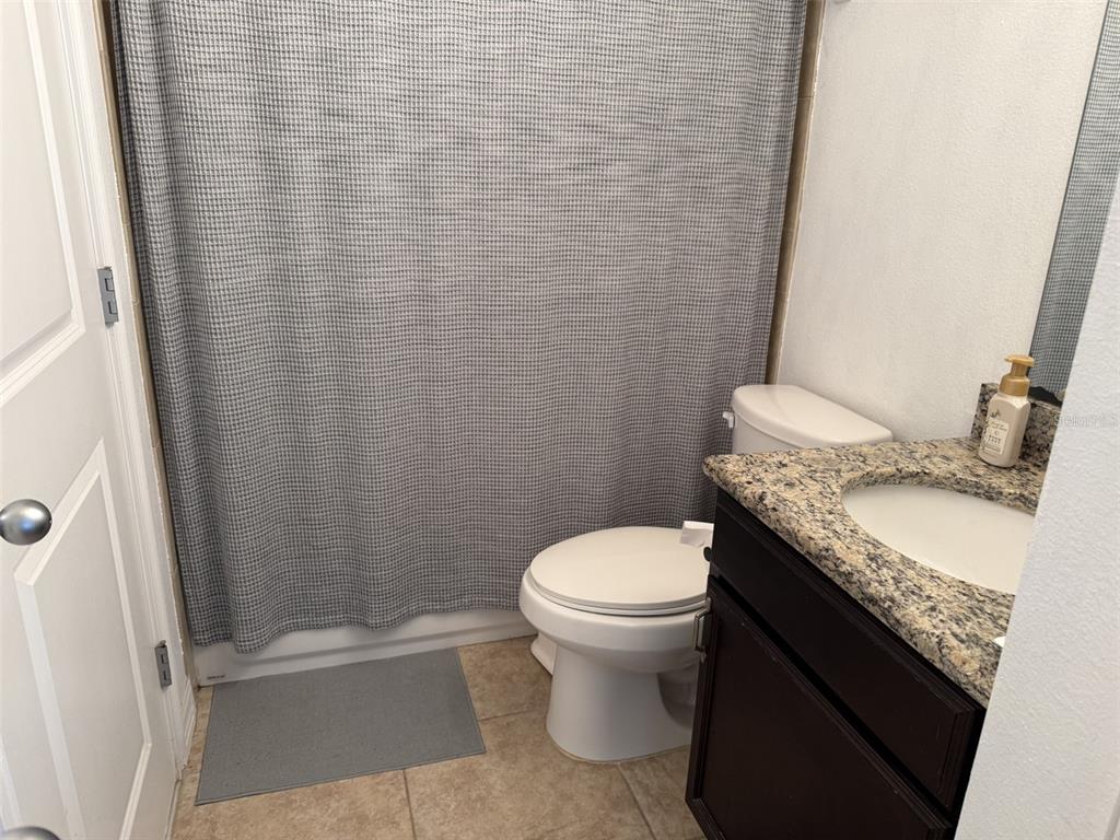 4639 Southwest 48th Drive, Unit 149 Gainesville, FL 32608 - Photo 11 of 13 a bathroom with a granite countertop sink toilet and shower