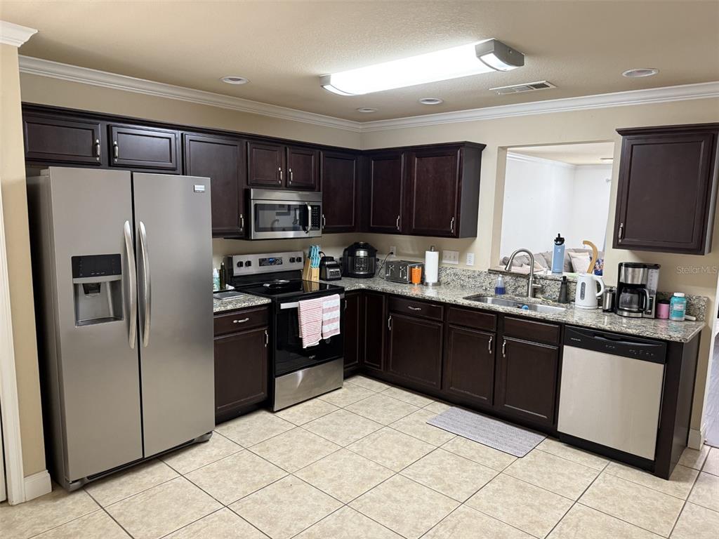 4639 Southwest 48th Drive, Unit 149 Gainesville, FL 32608 - Photo 5 of 13 a kitchen with stainless steel appliances granite countertop a refrigerator stove a sink and dishwasher