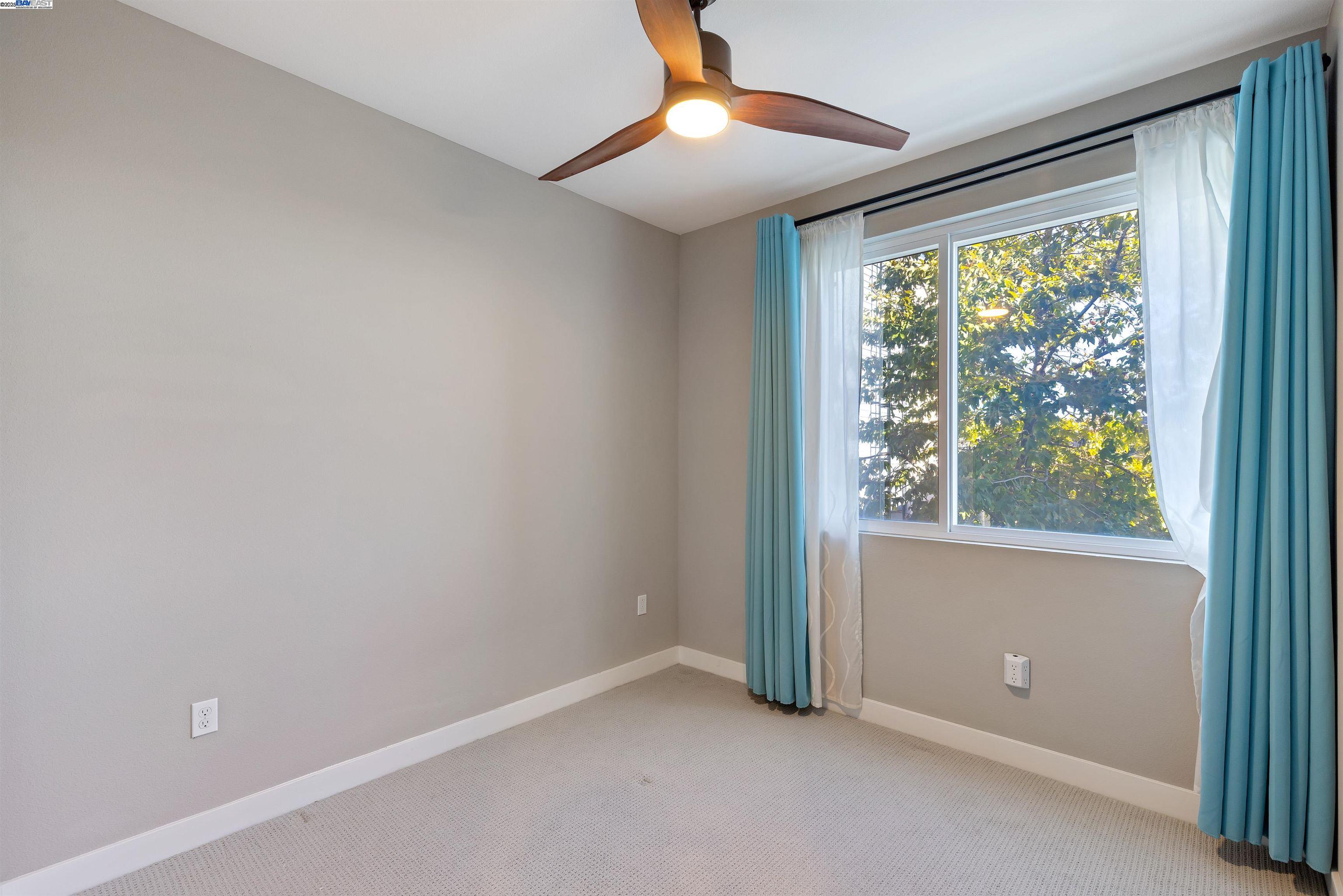 3957 Wattling Street Oakland, CA 94601 - Photo 11 of 23 an empty room with a window and a ceiling fan