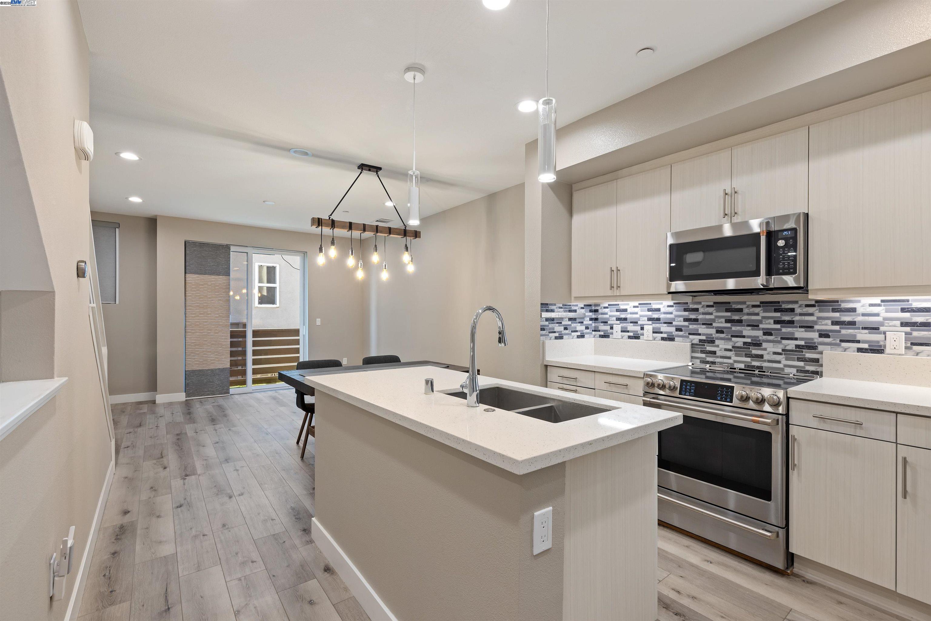 3957 Wattling Street Oakland, CA 94601 - Photo 5 of 23 a kitchen with a sink stove and cabinets