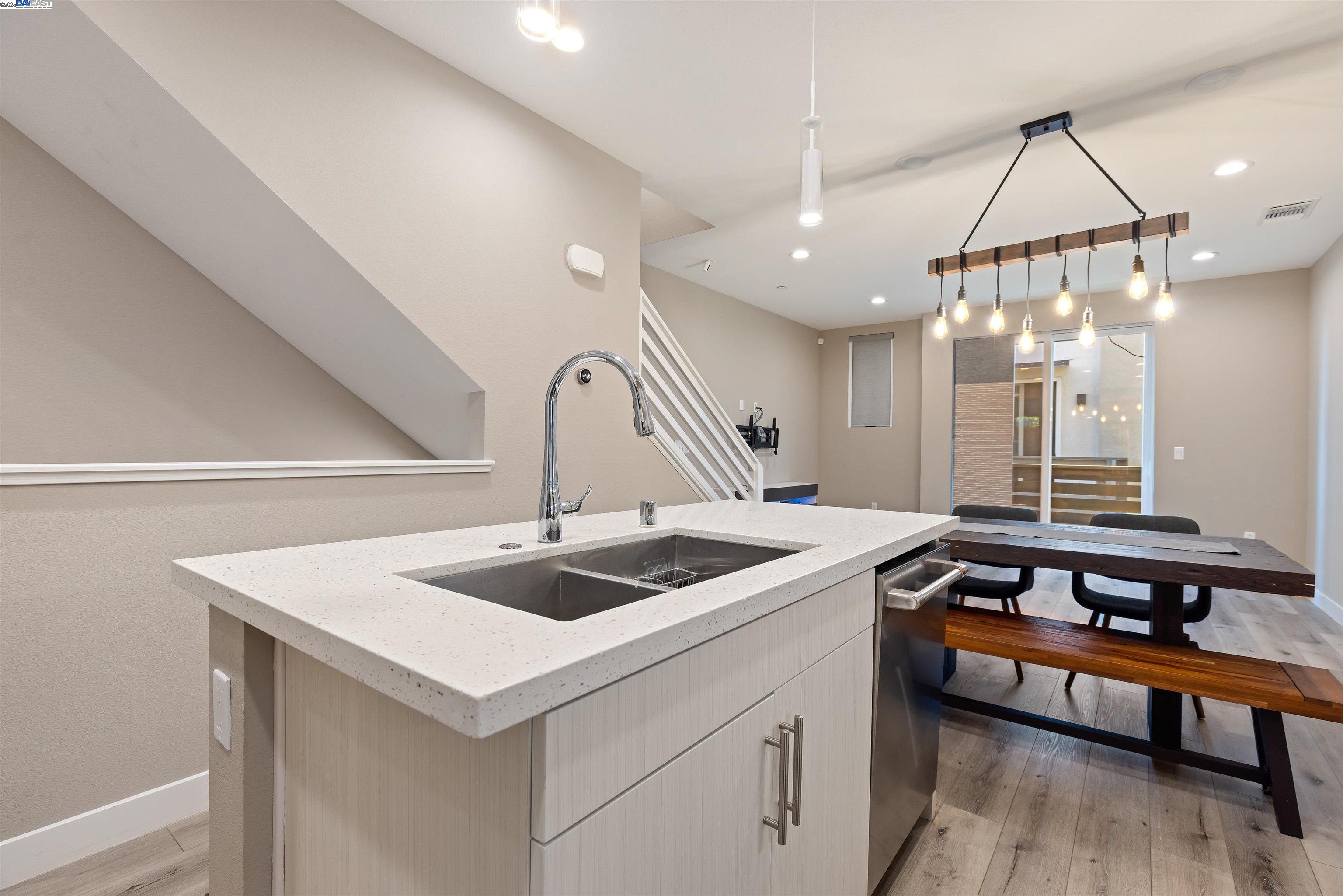 3957 Wattling Street Oakland, CA 94601 - Photo 6 of 23 a kitchen that has a sink a table and chairs in it