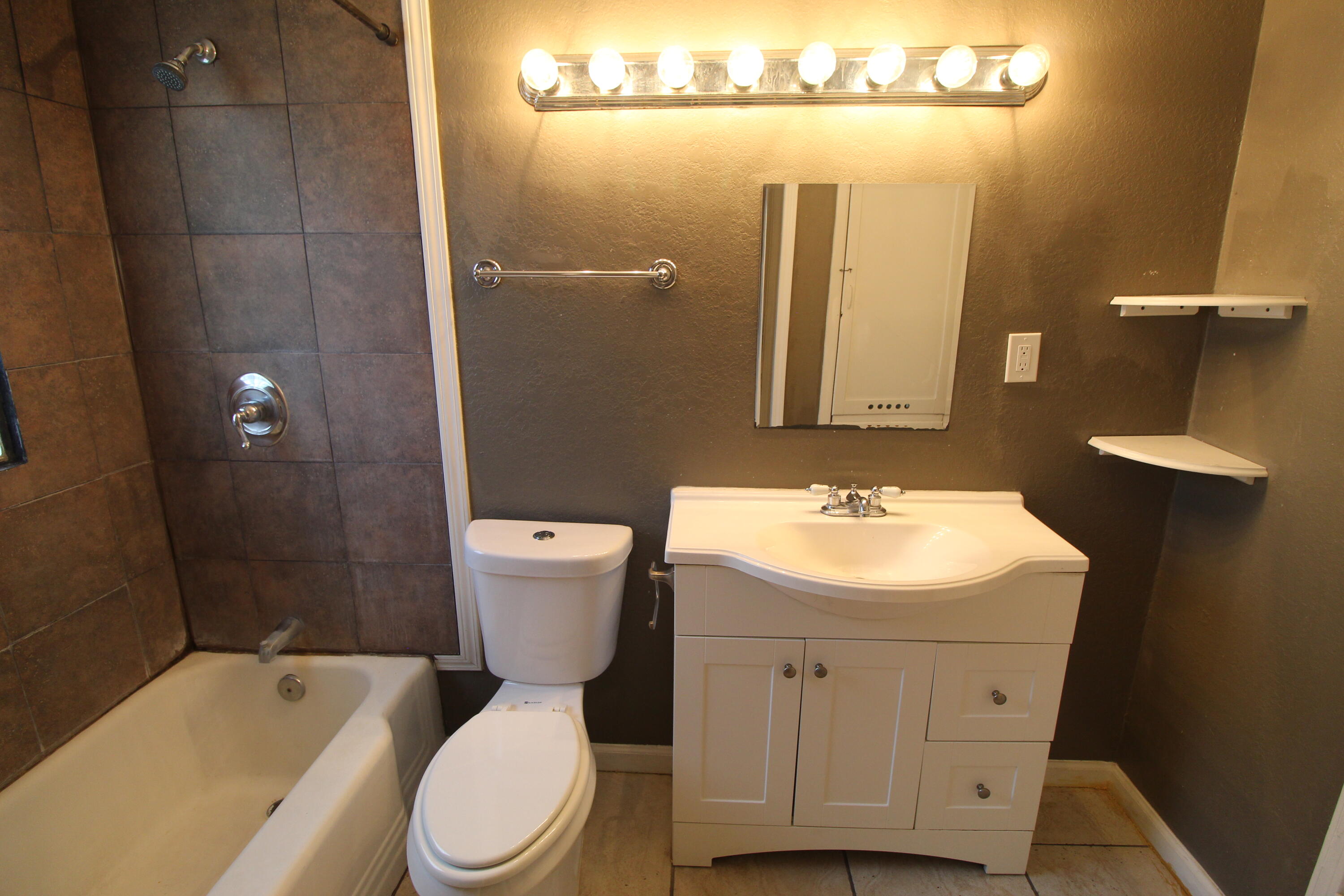 2209 25th Street Lubbock, TX 79411 - Photo 16 of 22 a bathroom with a sink a toilet a mirror and shower