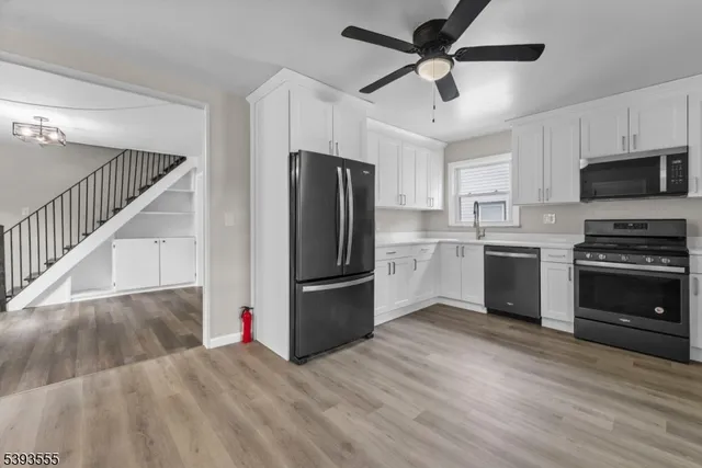 a kitchen with a refrigerator and a stove top oven