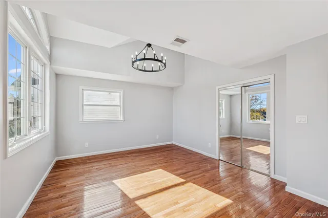 a bedroom with a large bed and a chandelier