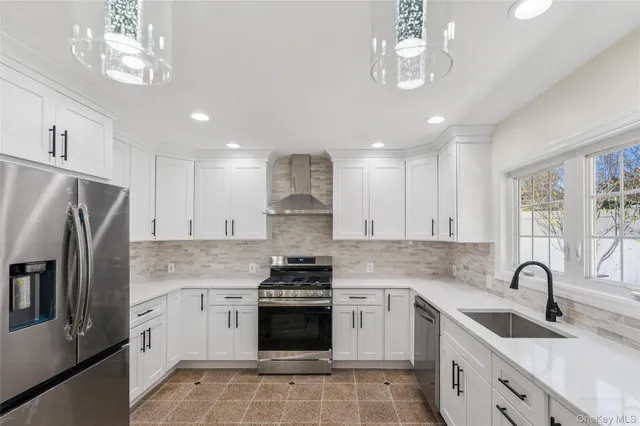 a kitchen with granite countertop a sink stainless steel appliances and cabinets