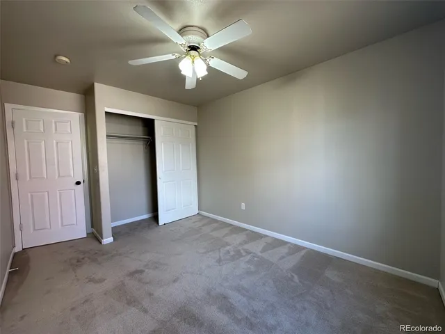 an empty room with a chandelier fan and a ceiling fan
