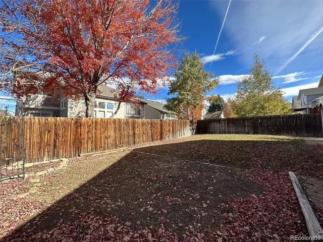 a view of backyard with wooden fence