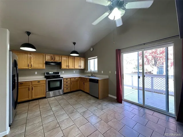 a large kitchen with a large window and stainless steel appliances
