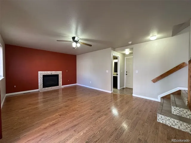 a view of empty room with wooden floor and fireplace