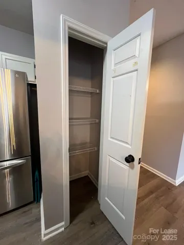 a view of a livingroom with wooden floor and a ceiling fan