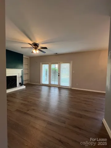 a view of empty room with wooden floor and fireplace