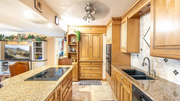 a kitchen with granite countertop a sink and a refrigerator