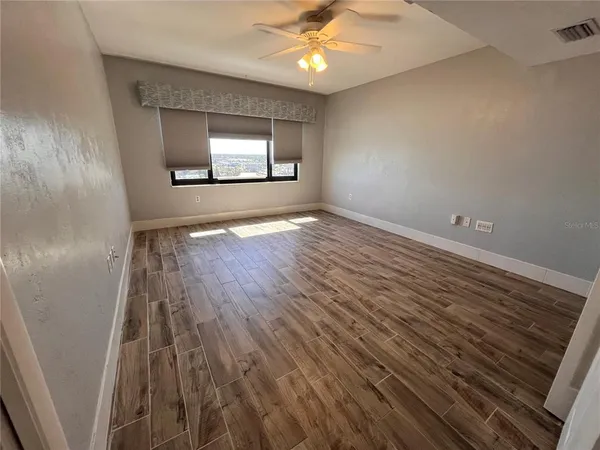 wooden floor in an empty room with a window