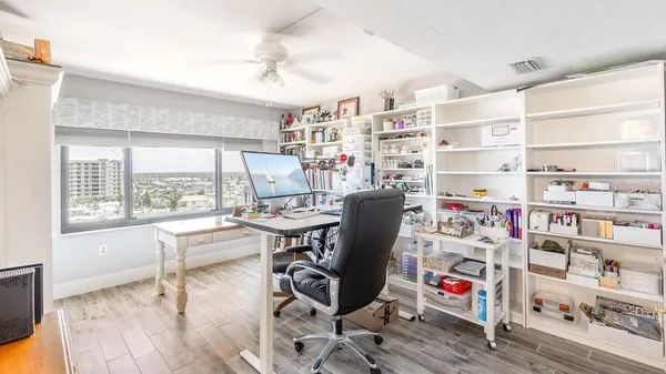 a view of a workspace with furniture and a window