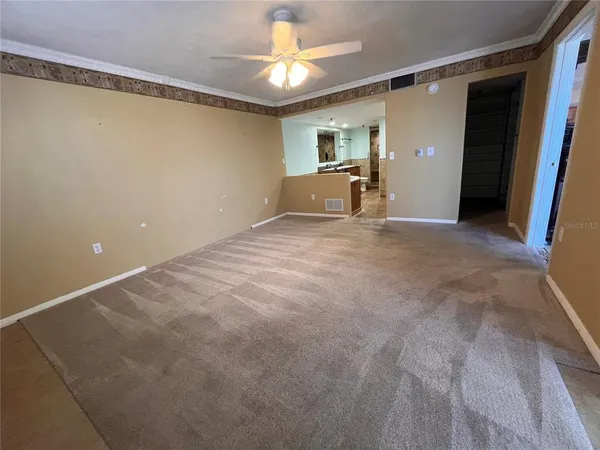 a view of empty room with a ceiling fan and window