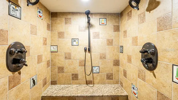 a bathroom with a granite countertop shower and a mirror