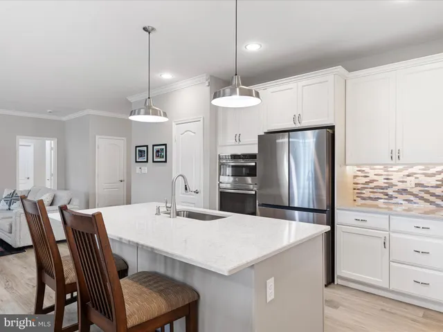 a kitchen with a refrigerator a stove a dining table and chairs