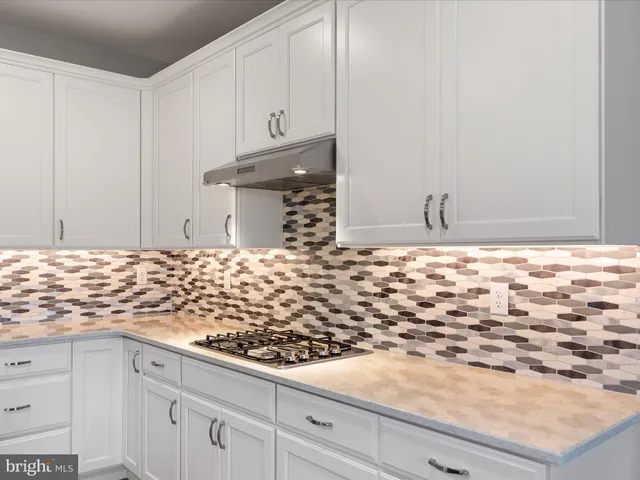 a bathroom with granite countertop white cabinets and a sink