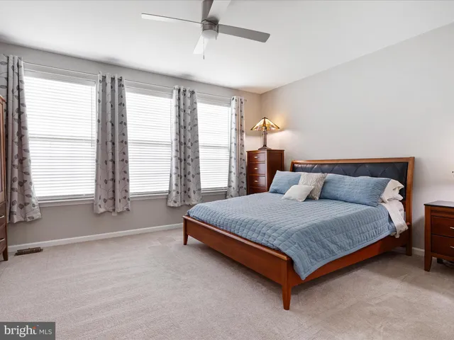 a spacious bedroom with a bed and large windows