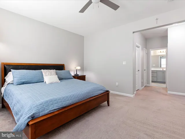 a bed sitting in a bedroom and view of kitchen