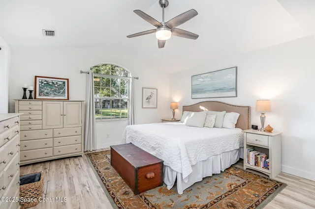 a bedroom with a bed chandelier and a window