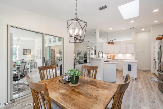 a dining room with stainless steel appliances kitchen island granite countertop furniture and wooden floor