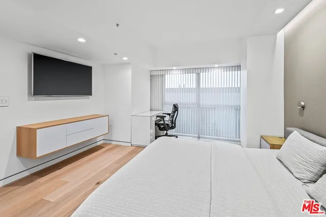 a bedroom with a bed and a flat screen tv