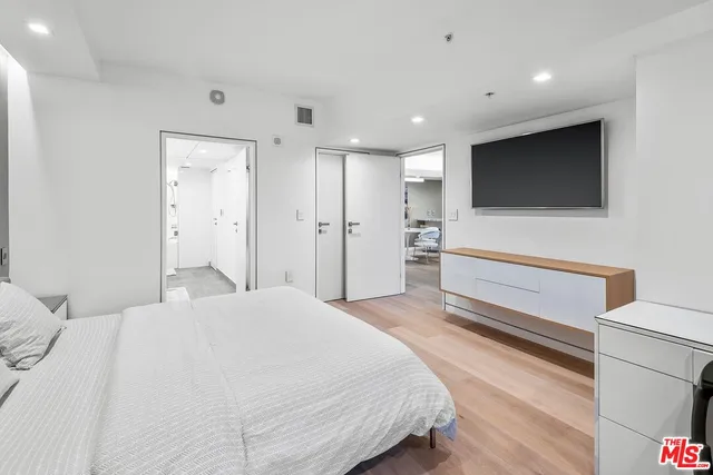 a bedroom with a bed and a flat screen tv