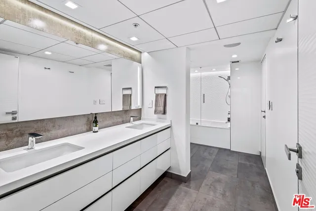 a bathroom with a double vanity sink and mirror with shower