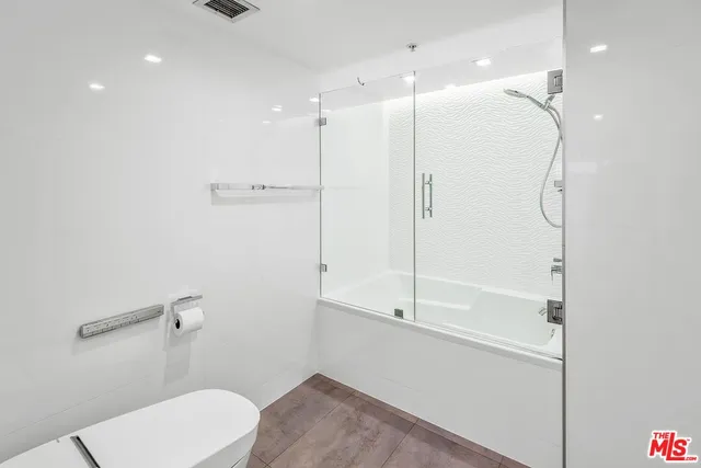 a bathroom with a shower a toilet and a shower