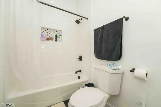 a white toilet sitting next to a bath tub and a shower