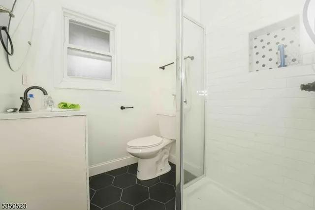 a bathroom with a toilet sink vanity and mirror