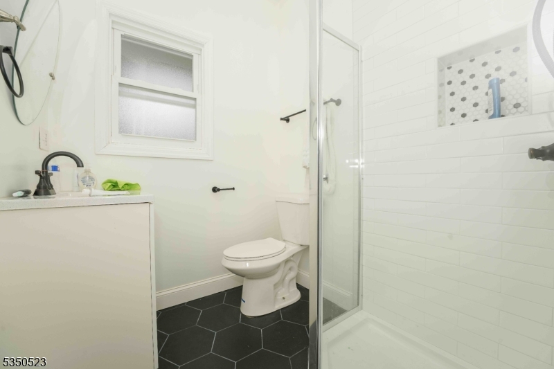 21 Woodland Road Bloomfield, NJ 07003 - Photo 14 of 20 a bathroom with a toilet sink vanity and mirror
