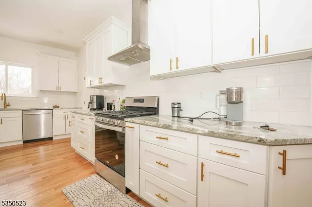 a kitchen with cabinets appliances a sink and a window